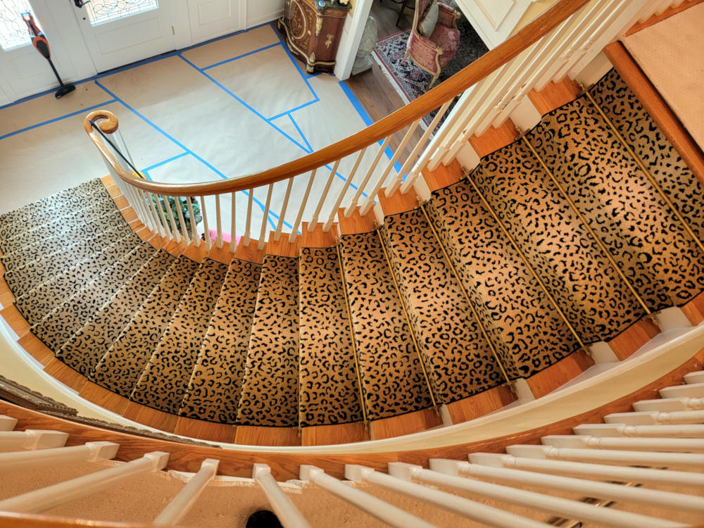 Animal print carpet highllighted with lighter center and stair rods seen from above,