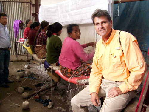 Portrait of Gary Dicus in front of a rug loom