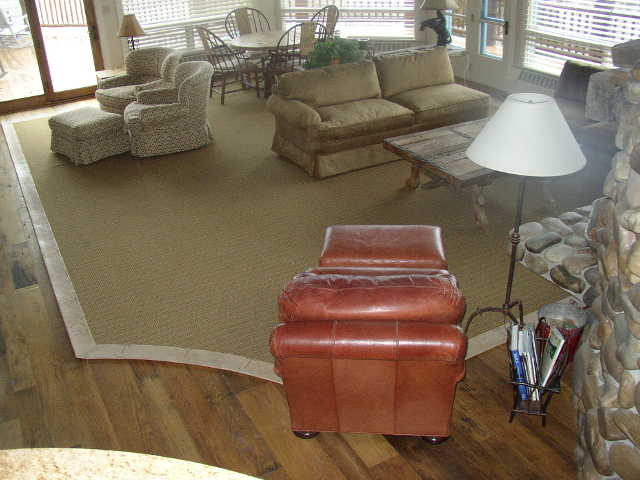 Large fabricated rug with wide hand sewn leather binding
