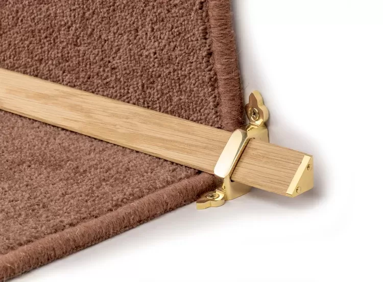 Light wood stair rod with brass bracket