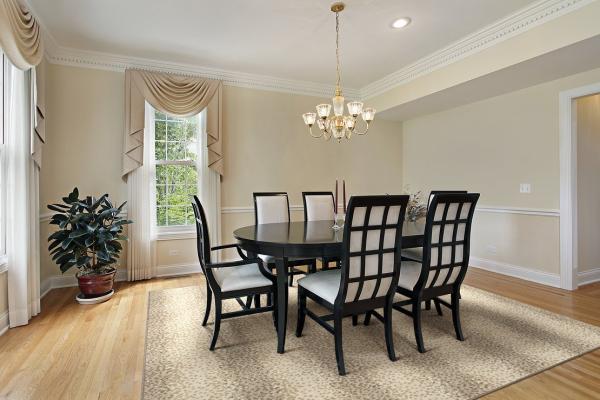Dining room table and chairs on animal print rug.
