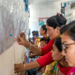Weavers busy working on a rug.